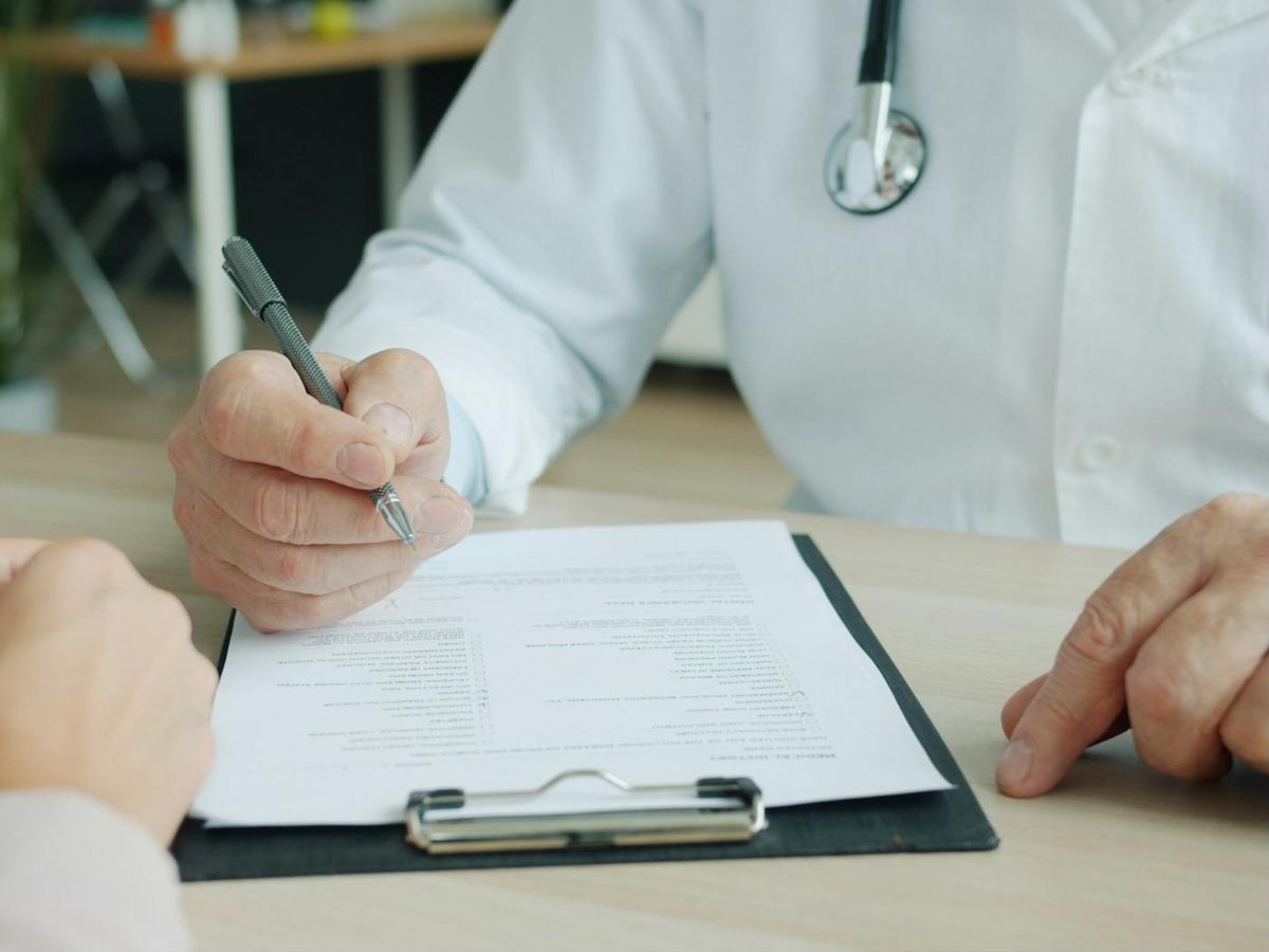 Médico firmando un certificado médico oficial